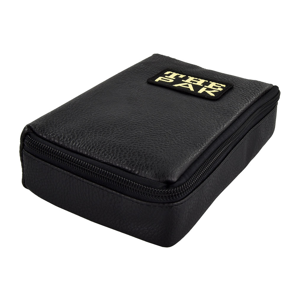 Black, rectangular dart bag crafted from grained imitation leather, shown in an overhead angled view. Zip fastening along three sides of the lid. Gold-coloured label at the top bearing the inscription "THE PAK". Sleek and compact.