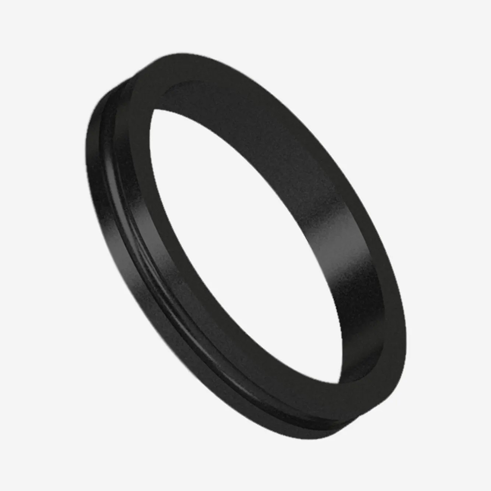 Un anneau Pro Grip rond, noir mat, avec un rebord intérieur légèrement surélevé. Légèrement incliné sur un fond gris clair, il révèle sa texture robuste et adhérente. Target Anneau Pro Grip pour les fléchettes ou les sports similaires.