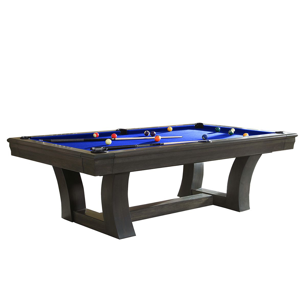 Une élégante table de billard gris foncé avec un tapis bleu roi sur une surface blanche. Des boules de billard colorées et deux queues sont disposées sur le plateau. Des pieds robustes aux formes modernes et incurvées.