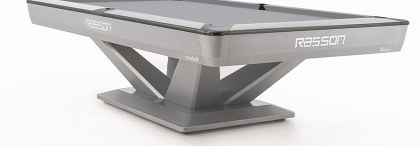 Table de billard moderne gris clair avec surface de jeu gris foncé, sur fond blanc. Côtés ornés des logos « Rasson », « nineball » et « Victory ». Piètement en V avec large socle, dynamique et stable. Minimaliste.