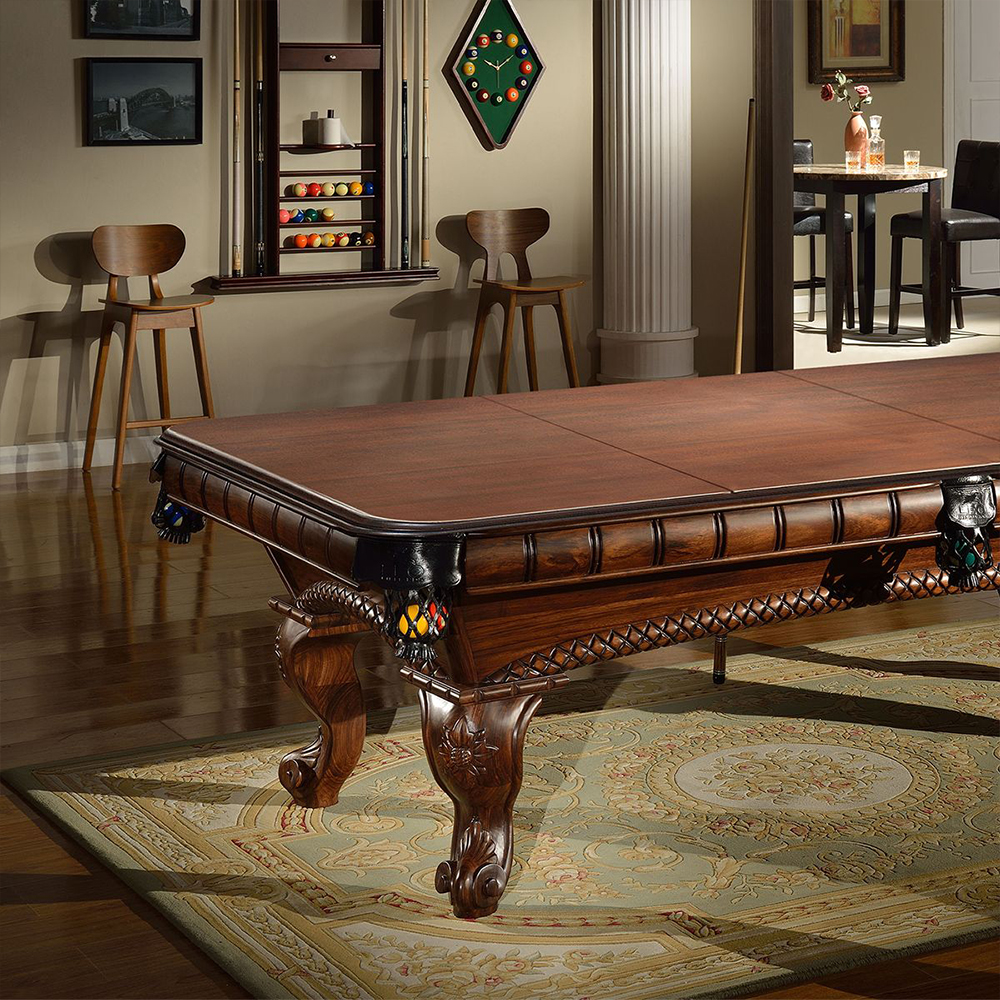 Somptueuse table de billard Arizona en bois massif brun foncé, look antique avec incrustations. Plateau en trois parties pour se transformer en table à manger. Pieds décorés, tournés et sculptés. Étagère boules/queues à l'arrière.