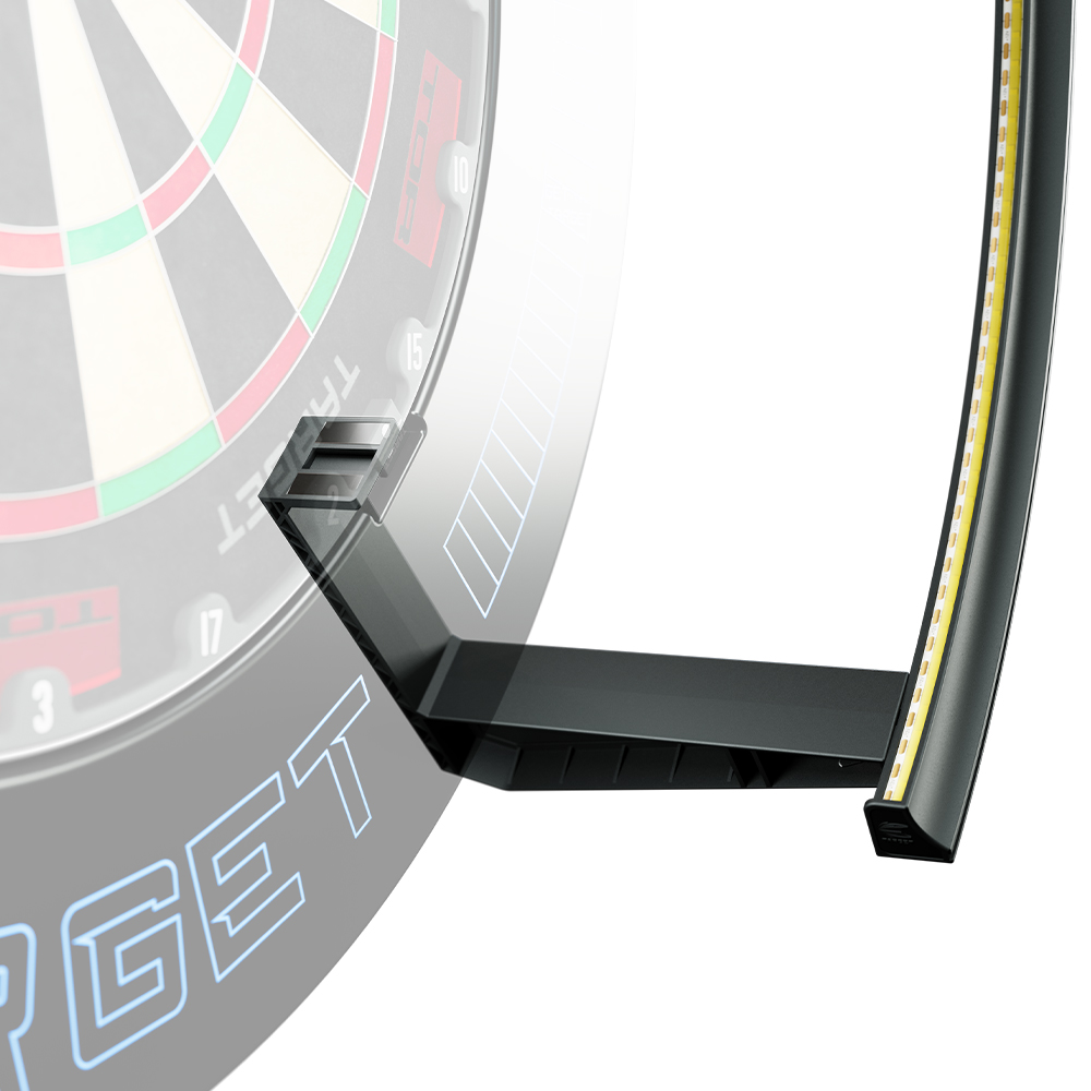 Gros plan sur le système d'éclairage noir et annulaire « Target Corona Vision 2 » pour cibles de fléchettes, qui entoure partiellement une cible floue en arrière-plan. Avec des bandes LED jaunes à l'intérieur et des supports pour une fixation magnétique.