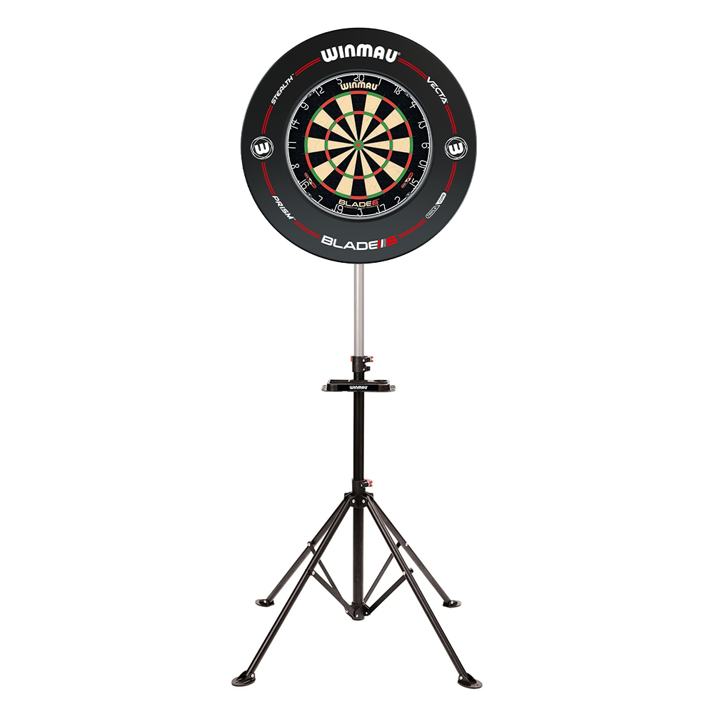 Winmau Cible Blade 6 sur un trépied noir à trois pieds, sur fond blanc. Surface de jeu classique avec des segments noirs, rouges, verts et de couleur naturelle, entourée d'un anneau de protection noir rehaussé de touches rouges et d'un logo.