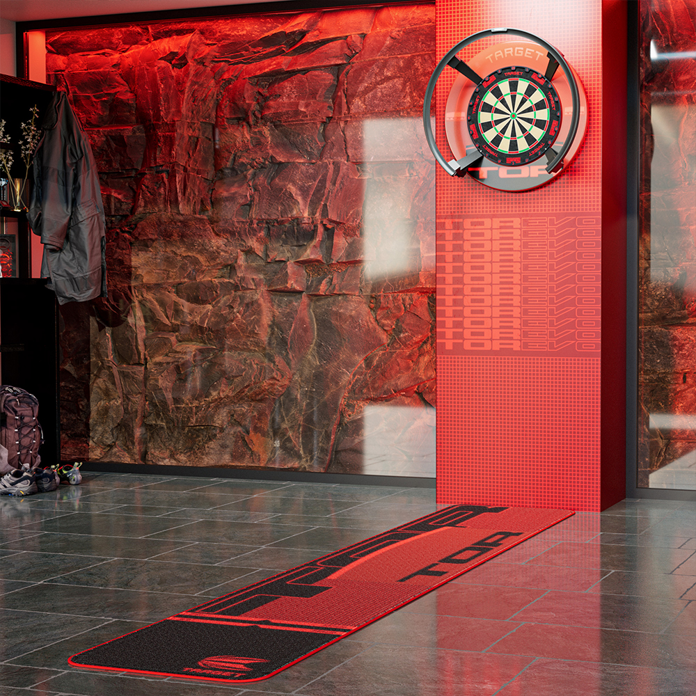 Le tapis de fléchettes TOR « Target » rouge et noir, sur sol carrelé gris, mène à un mur rouge avec une cible « Target » éclairée. La lumière rouge et le mur en pierre créent un cadre professionnel. Lignes de lancer visibles.
