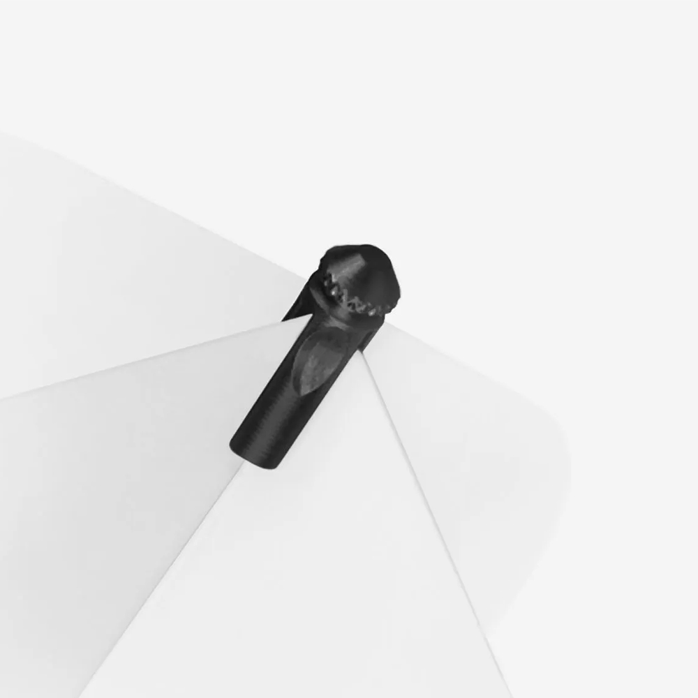 A black Flyprotector is positioned between two white dart flights. It is cylindrical with a textured, rounded top. The component protects the flights from collisions and wear caused by subsequent darts.