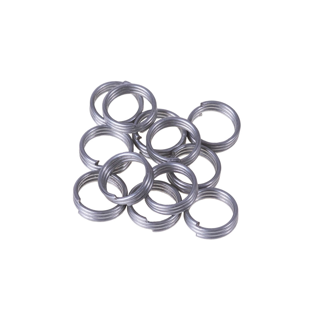 Douze anneaux à ressort argentés brillants en acier inoxydable reposent sur un fond blanc. Ces petits anneaux ronds sont légèrement ouverts et rainurés en spirale. Ils fixent solidement les plumes de fléchettes sur les tiges en nylon ou en plastique.