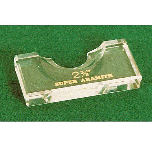 Transparent, rectangular acrylic block used as a position marker for billiard balls. Features an open-topped, semi-circular recess to hold a ball securely. Gold lettering reading "2 3/8"" and "SUPER Aramith". On green billiard felt.