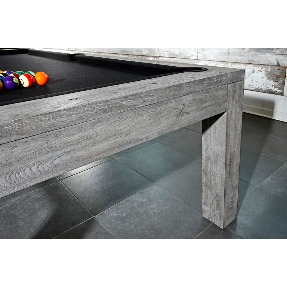 Modern Brunswick Sanibel pool table, 8ft, Rustic Grey, solid wood with visible, weathered grain. The side rails and one table leg feature the grey texture. Colourful balls are scattered across the black playing surface.