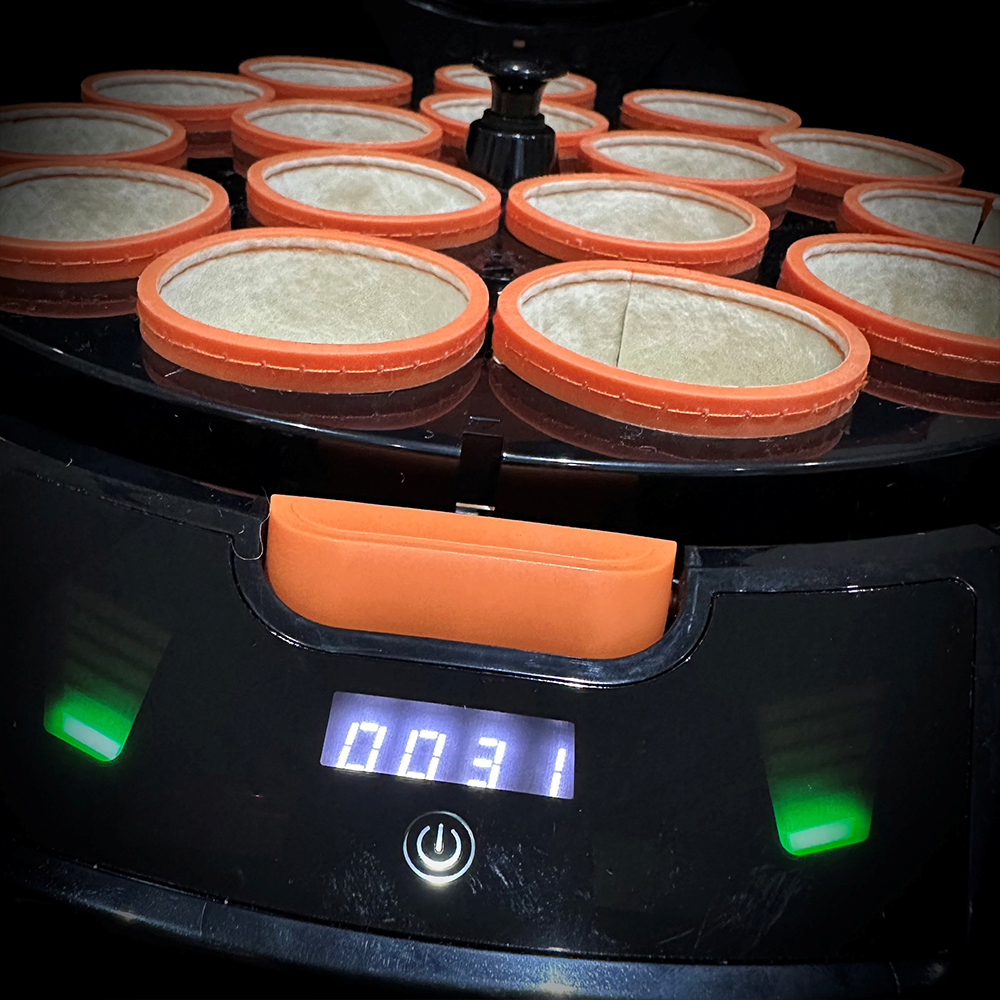 Nahaufnahme des oberen Teils einer schwarzen Billard-Kugelpoliermaschine GEN 5 mit vielen runden Wollbechern in orangefarbenen Ringen. Unten zeigt eine Digitalanzeige 0031 und grüne Kontrollleuchten den Betrieb an.