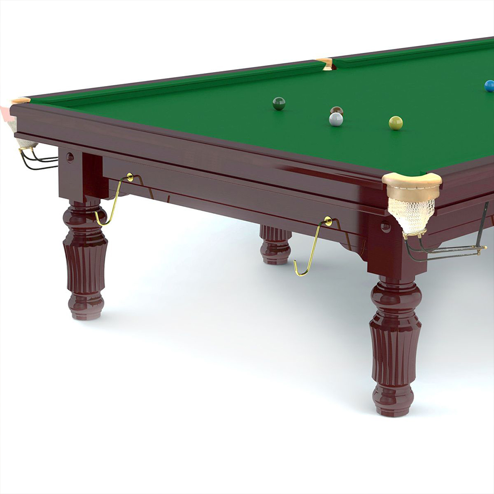 Table de billard marron foncé avec une surface de jeu en feutre vert et des pieds décorés. Des boules de billard vertes, marron, blanches, jaunes et bleues sont disposées sur la table. Crochets dorés pour les queues et filets blancs aux coins.